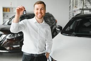 Oui, c'est mon Nouveau auto. client dans voiture concession. Jeune homme avec clés dans main. photo