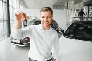 content homme montrant le clé de le sien Nouveau auto. photo