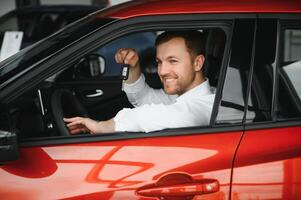 Oui, c'est mon Nouveau auto. client dans voiture concession. Jeune homme avec clés dans main. photo