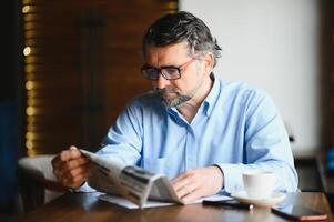 café Pause. homme en buvant café et en train de lire journal dans café bar photo