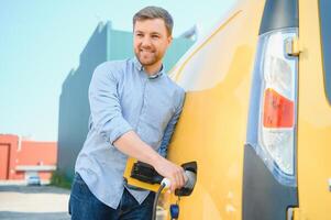 homme mise en charge électrique véhicule avec câble photo