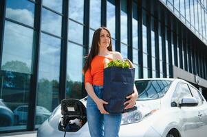 éco électrique voiture concept. femme attendre électrique voiture à charge. photo