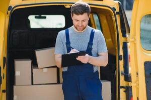 Jeune livraison homme courrier dans uniforme tenir les documents presse-papiers vérification liste parcelle Publier des boites près une voiture pour un service expédition à client, en ligne achats un service concepts. photo