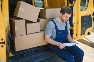 courrier un service pour le livraison de marchandises. Express un service une homme dans une uniforme livre des boites. le employé porte le commande Accueil à le client. photo