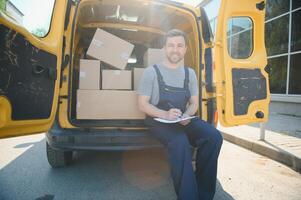 Jeune livraison homme courrier dans uniforme tenir les documents presse-papiers vérification liste parcelle Publier des boites près une voiture pour un service expédition à client, en ligne achats un service concepts. photo