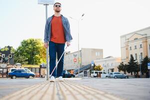 aveugle homme. gens avec invalidité, handicapé la personne et tous les jours vie. visuellement altéré homme avec en marchant bâton. photo