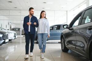 c'est la seule voiture que je veux. beau jeune couple debout chez le concessionnaire choisissant la voiture à acheter photo