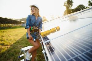 femmes ingénieur travail sur vérification équipement à vert énergie solaire Puissance plante vérification solaire panneau et structure avec tablette liste de contrôle photo