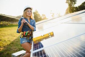 femmes ingénieur travail sur vérification vérification statut équipement à solaire Puissance plante. femme travail sur Extérieur à solaire Puissance plante photo