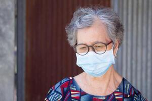 portrait de un personnes âgées femme portant une chirurgical masque avec une inquiet. masque pour protéger virus, corona virus, COVID-19 [feminine, pollen céréales, et plus. concept de vieilli gens et soins de santé photo