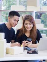 asiatique Jeune couple est une Nouveau commerce électronique entrepreneur, travail comme travail en équipe et en utilisant divers les technologies l'Internet pour le entreprise. concept de affaires et commerce électronique photo