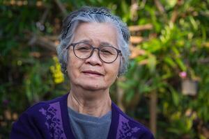 portrait de une personnes âgées femme dans sa jardin. photo