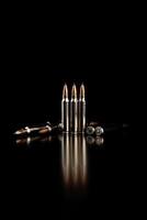 balle isolé sur noir Contexte avec réflexion. fusil balles fermer sur noir dos. cartouches pour fusil et carabine sur une noir. photo