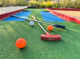 coloré le golf putters avec le golf des balles sur synthétique herbe photo
