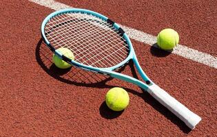 raquette avec une tennis Balle sur une rouge argile rechercher. photo