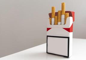 ouvert pack de cigarettes et une cigarette sur une blanc Contexte. photo