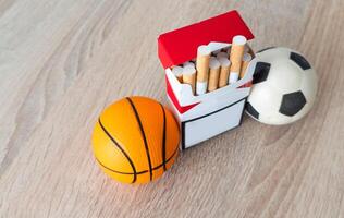 fumeur ou des sports. sport Balle et pack de cigarettes sur table Contexte. Haut vue photo