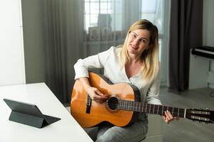 Jeune femme en jouant sa guitare à Accueil photo