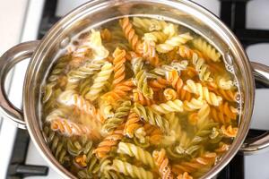 italien fusilli pâte est cuit dans une pot sur le poêle. Haut voir. sélectif se concentrer. photo