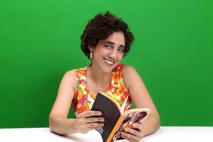 Jeune femme en train de lire et l'écriture à sa bureau photo