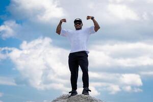 fort Beau homme posant pour caméra sur bleu ciel. attrayant Jeune mode de vie homme. photo