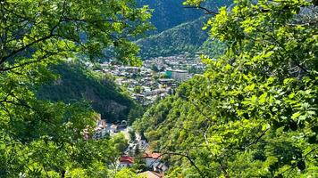 grztya, tbilissi. Borjomi historique parc. mai 19, 2024. scénique aérien vue de luxuriant vert vallée avec village niché parmi le montagnes en dessous de bleu ciel avec des nuages. Voyage la photographie. photo