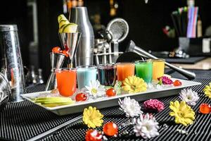 rafraîchissant boisson plateau avec coloré fleurs sur table photo