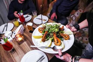 groupe de gens profiter une repas ensemble à une table photo