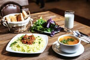 en bois table avec bol de soupe et assiette de nourriture photo