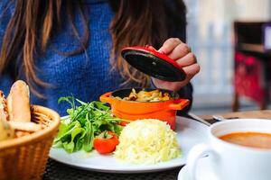 femme séance à table avec assiette de nourriture photo