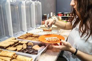 femme permanent dans de face de table avec plateaux de nourriture photo