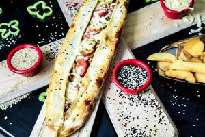 longue sandwich sur Coupe planche avec bol de frites photo