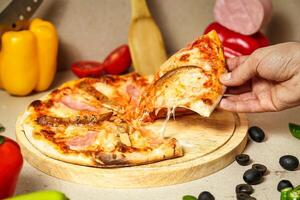 la personne prise une tranche de Pizza de une Coupe planche photo