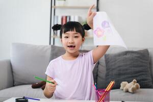 une Jeune fille est dessin une image sur une pièce de papier photo