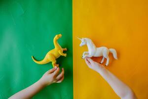 deux les enfants sont en portant deux différent jouets, une dinosaure et une Licorne photo