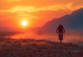 homme monte Montagne bicyclette sur poussiéreux route à le coucher du soleil. photo