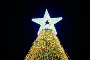Noël arbre avec gros blanc étoile topper décoré Jaune guirlandes et coloré décoratif ampoules photo