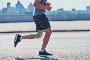 athlétique homme le jogging dans tenue de sport sur ville route photo