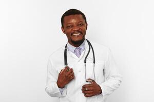 souriant noir barbu médecin homme dans blanc peignoir avec stéthoscope, isolé sur blanc Contexte photo