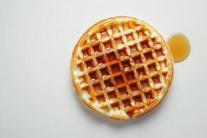 Haut vue de une gaufre avec érable sirop sur blanc Contexte photo