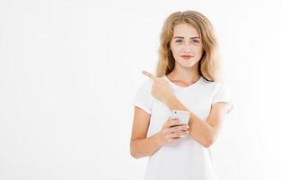 Smiling attractive girl, woman holding cellphone doigt pointé isolé sur fond blanc, hand holding black phone, copy space photo