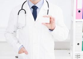 médecin montrant sa carte de visite, concept médical, assurance médicale, homme en uniforme blanc. espace de copie photo