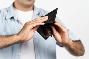 homme bouleversé tenant à l'envers et regardant à l'intérieur de son portefeuille vide sur fond blanc. crise financière, faillite, pas d'argent, concept de mauvaise économie. photo