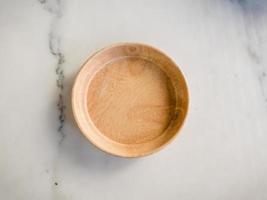 une assiette en bois sur une table blanche photo