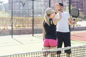 des sports couple avec padel raquettes posant sur tennis tribunal photo