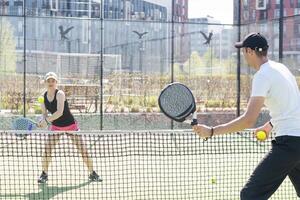 des sports couple avec padel raquettes posant sur tennis tribunal photo