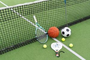 une variété de des sports équipement comprenant un américain football, une football balle, une tennis raquette, une tennis balle, et une basketball photo