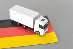 mini jouet à table avec flou Contexte. industriel livraison concept. jouet camion, Allemagne drapeau photo