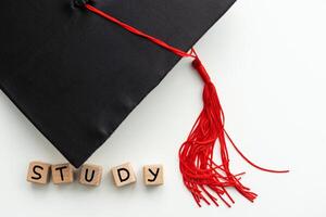 l'obtention du diplôme casquette avec rouge gland isolé sur blanc Contexte photo