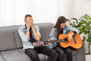 une père enseignement le sien fille Comment à jouer guitare. photo